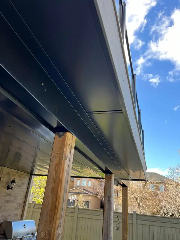 Black metal soffit and fascia under a deck, seen from below