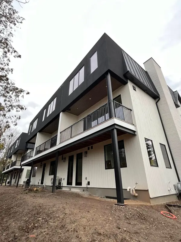 Three-storey townhouses with black metal upper cladding and balconies