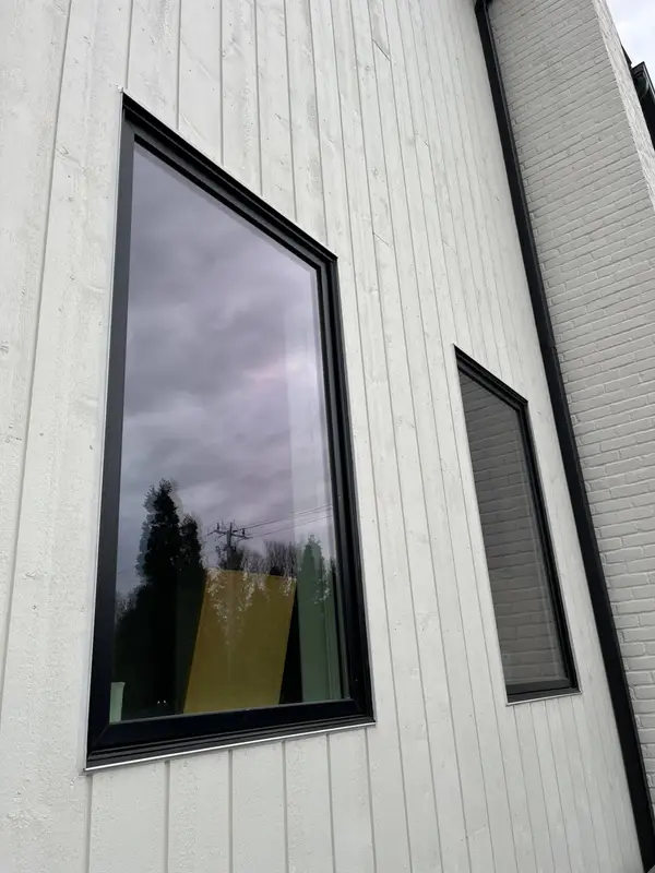White vertical siding around black-framed windows