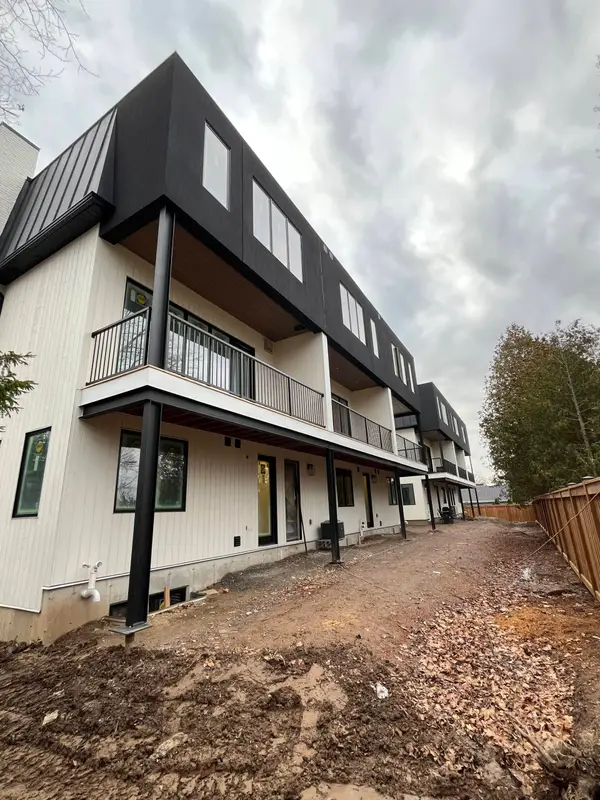 Townhouse row with black metal cladding, white siding and balconies