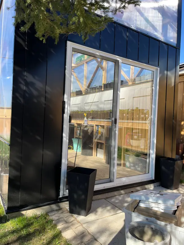 Black flat wall panels around a sliding glass door