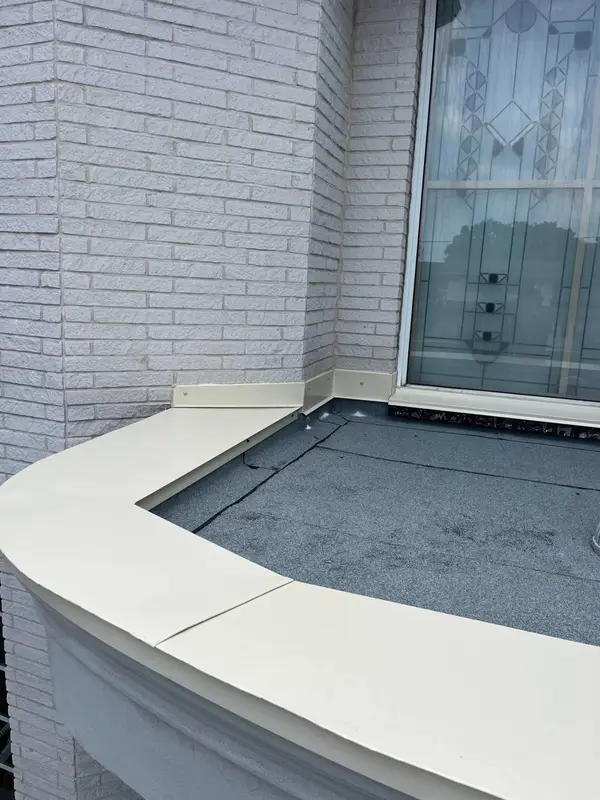 Curved masonry ledge finished with a light metal cap flashing