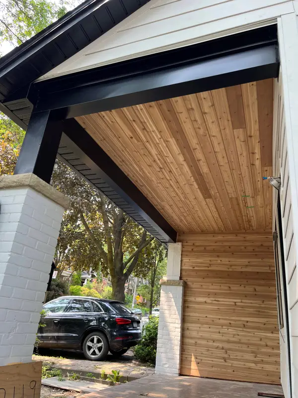 Covered porch with a cedar ceiling and black metal-wrapped beam