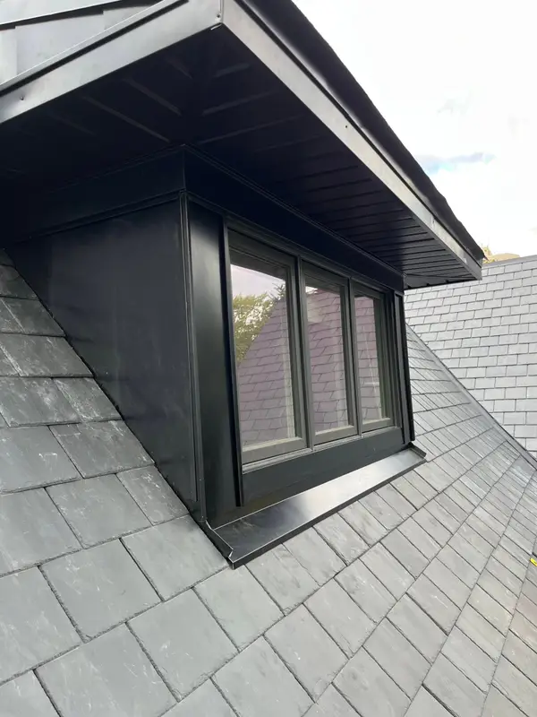 Black metal-clad dormer on a slate roof