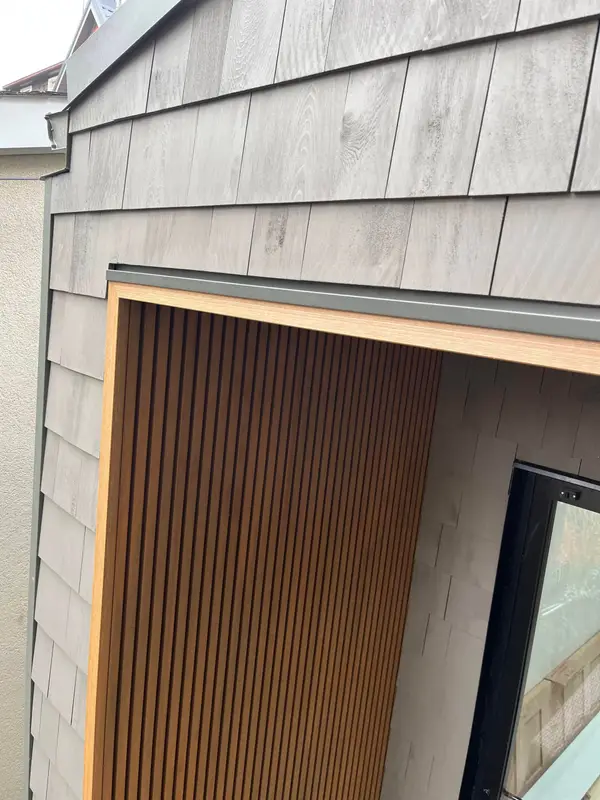 Light grey shingle-style siding with a wood slat accent
