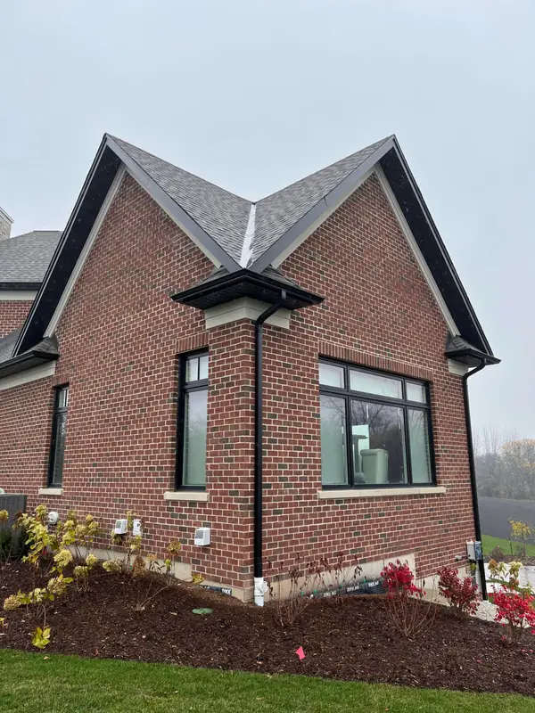 Brick house with a black metal roof over the bay window