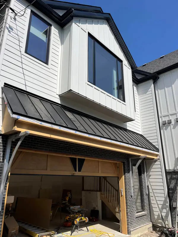 New build with a black metal awning and vertical siding