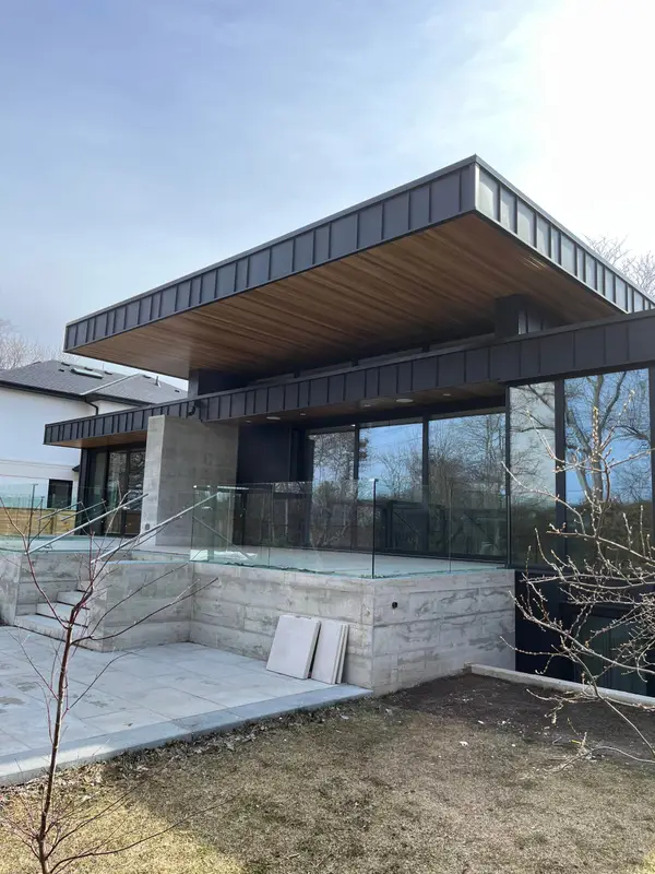 Modern home with black metal fascia, wood soffit and glass railings