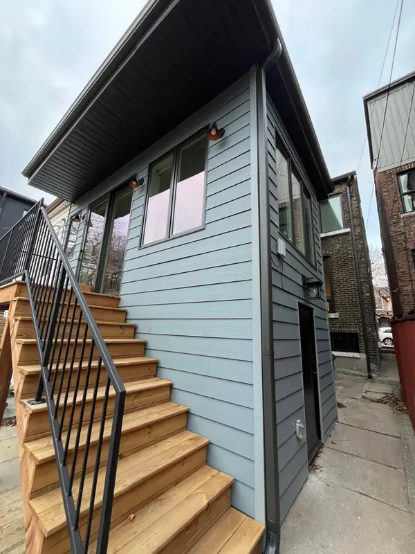 Grey lap siding on a backyard unit with wood stairs